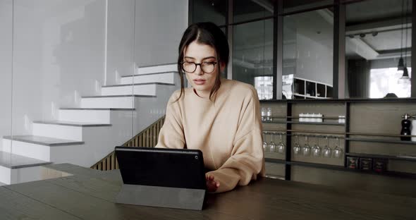 Beautiful Woman at Home Using Digital Tablet in Modern Kitchen Room alt