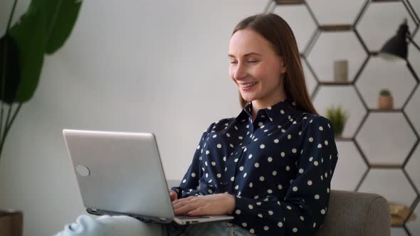 Woman Working on Laptop Computer Sitting on Sofa at Home alt