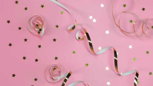 Flat Composition of Gold Ribbons or Serpentine and Gold Confetti in the From of Stars on a Pink