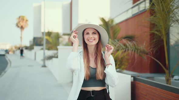 Woman in Summer Hat Smiling Sincerely on Camera Outdoors alt