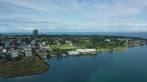 Aerial of peninsula city Suva on mainland of Fiji, view of Albert Park, urban alt