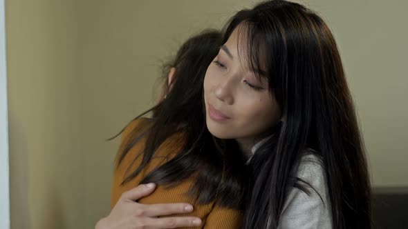 Asian Mother Gently Hugs Her Little Daughter