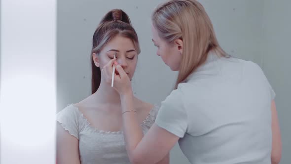 Make Up Artist Doing Putting Eye Shadow on Other Woman and Make Up Her