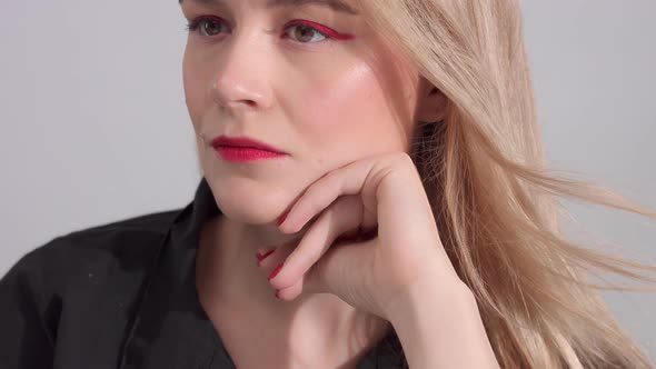 Blonde Woman with Bright Red Makeup in Studio