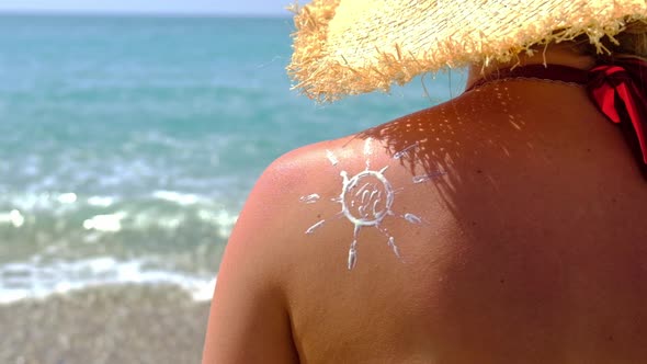 Woman on the Beach Smears Sunscreen alt