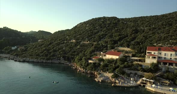 Small island covered with trees and rocky coast line alt