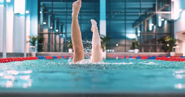 Female Swimmer in the Pool Young Woman Perform the Elements of Synchronized Swimming View of Legs alt