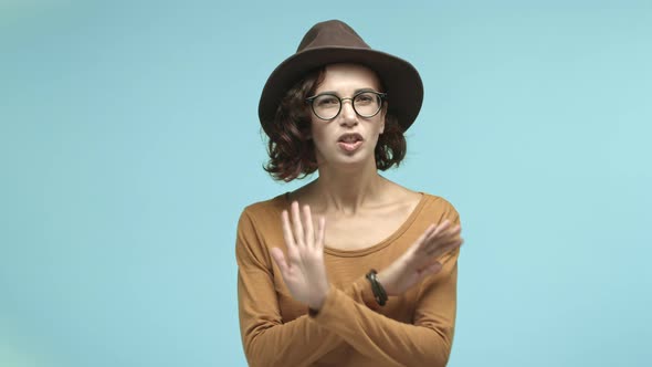 Stylish Young Woman in Glasses and Trendy Hat Saying No Shaking Hands in Refusal Rejecting Something