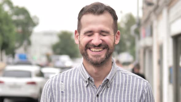 Outdoor Portrait of Laughing Young Man alt