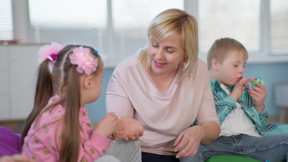 Female Teacher Working with Children with Down Syndrome for Lesson in an Inclusive School alt