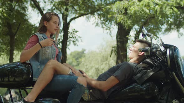 Young Cute Couple Travelers Relaixing on Motorbike alt