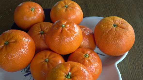 Tangerines lie in a plate on the table 