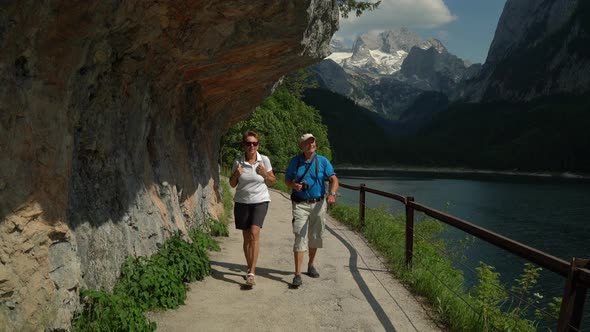 Happy Senior Couple Walking on Path at Mountain Lake
