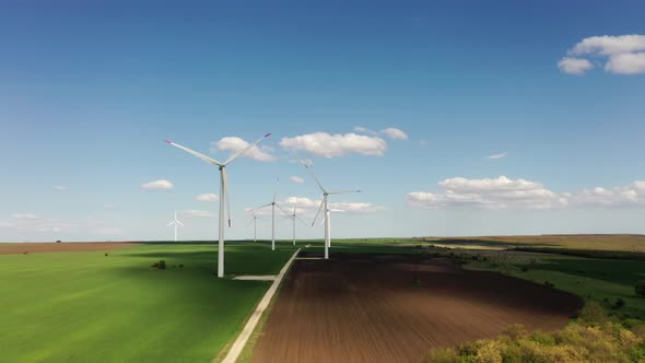 Wind Turbine Power Generator Farm at Beautiful Pure Blue Sky and Green Grass Background