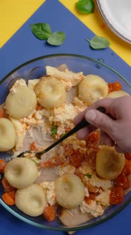 Vertical Tabletop Video Chef Takes Cooked Potato Dumpling with Tomatoes and Feta Cheese By Spoon