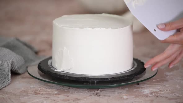 Close Up of Pastry Woman Spreading Cream on a Layered Cake