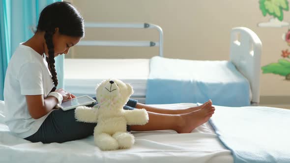 Girl using digital tablet on bed alt