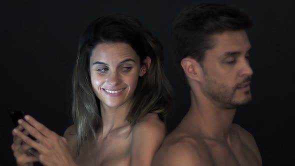 Woman absorbed in smartphone and ignoring boyfriend alt