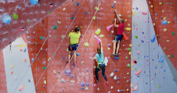 Men and woman practicing rock climbing in fitness studio 4k alt