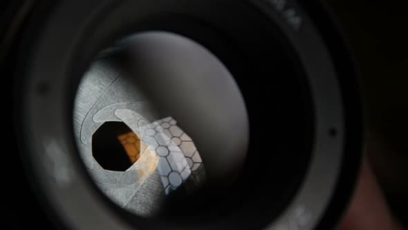 A Movement of the Aperture Flaps on the Camera Lens. Aperture Photo Lens Close-up. Multi-colored