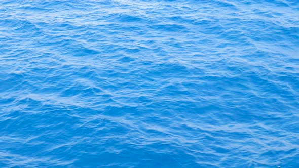 Background of Calm Sea. Sea with Little Waves Close Up. Blue Sea with Little Waves Texture.