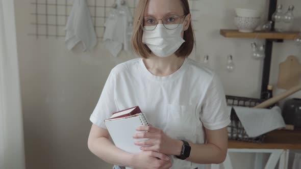 Portrait of a Young Woman in Mask and White Tshirt Books in Her Hands
