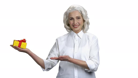 Beautiful Senior Woman Presenting Gift Box alt