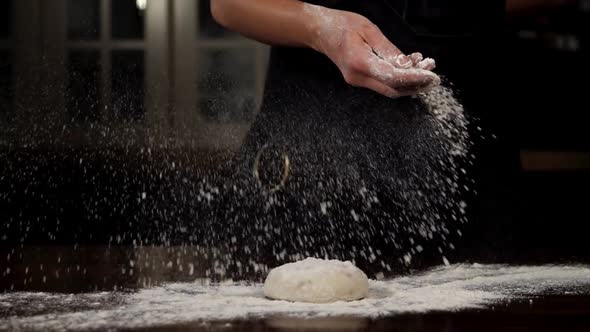 Baker is Sprinkling the Flour on the Dough in Slow Motion