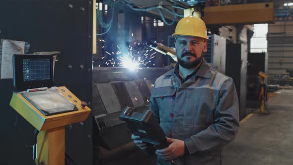 Workman Posing in Foreground of Welding alt