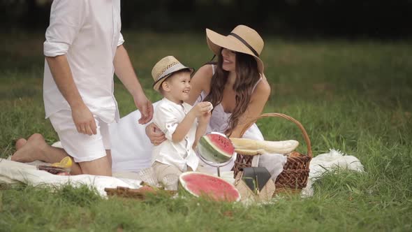 Loving Parents with Boy at Picnic on Summer Day