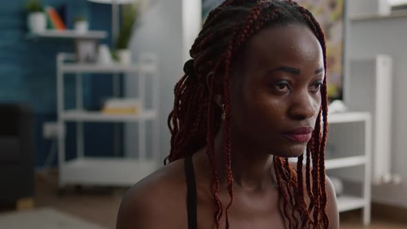 Fit Black Woman Sitting in Lotus Pose on Yoga Map with Closed Eyes alt