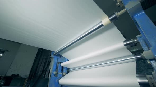 Bottom View of White Paper Rolling Through a Printing Mechanism alt