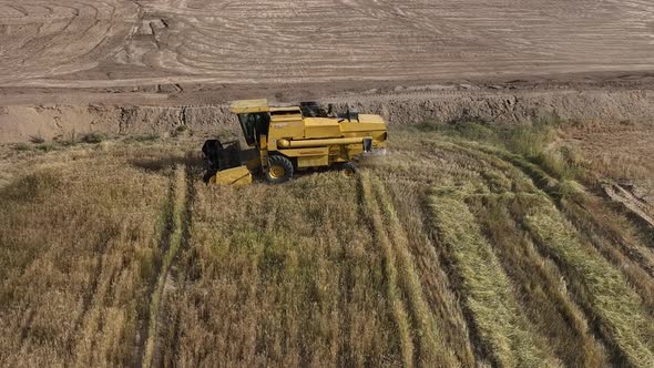 Aerial View Of Combine Harvester Working In Punjab Field In Pakistan. Tracking Shot alt