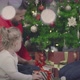 Happy Parents and Toddler Daughter Put Christmas Gifts Under Decorated Christmas Tree - VideoHive Item for Sale