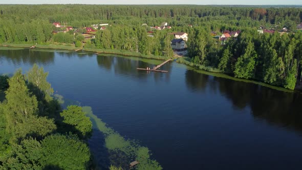 Aerial View Of Summer River Landscape And Small Village In Sunny Summer Evening