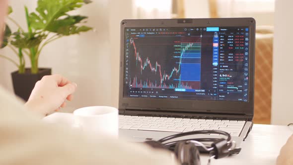 Cryptocurrency Market Chart on Laptop Screen Man Working at Home