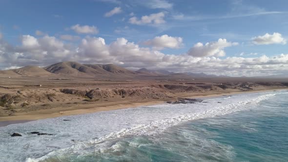 A Body of Water with a Mountain and Clouds in the Background