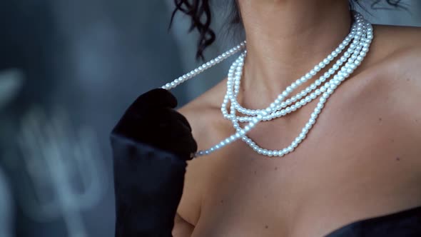 Seductive Brunette Woman Is Playing with Her Expensive Pearl Necklace and Smiling Broadly, Closeup alt