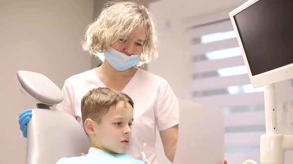 The child is afraid of the dentist, little boy visiting the dentist and looking scared alt