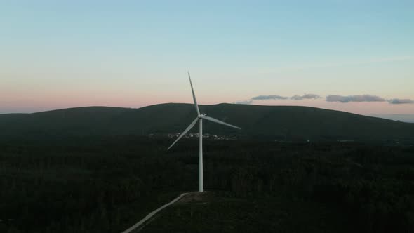 Working Wind Turbines With Mountain Ridges Background During Tranquil Sunset 