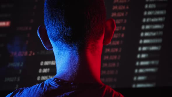 Trader Analyze Cryptocurrency Charts on a Big Screen in the Dark alt