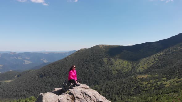 Meditation and Relaxation in the Mountains. Girl on a Mountain Peak. Unity with Nature. Mountains