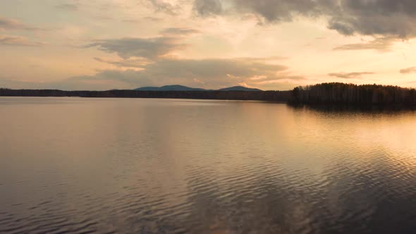 Aerial View of the Natural Landscape Forest on the Lake Shore at Sunset alt