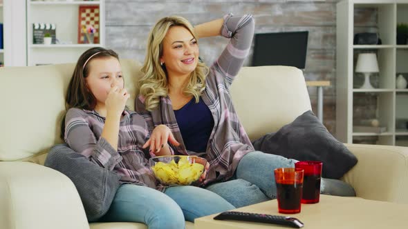 Little Girl Eating Chips While Watching Movie on Tv alt
