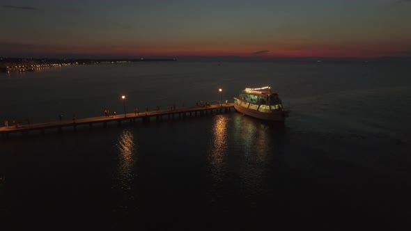 Aerial View of Pontoon on the Sea and People Walking on It From Cruise Boat at the Evening, Greece alt