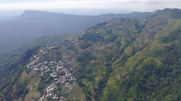Aerial view of cars driving on curved, zigzag curve road or street on mountain hill