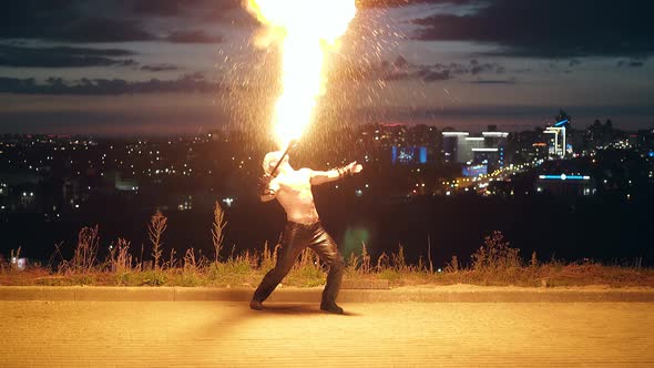 Young Blond Male Getting Ready to Perform Fire Show Fire Tricks Breaths Fire in the 2 Middle of the alt