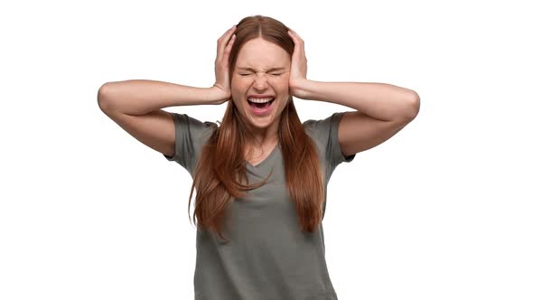 Portrait of Shocked Terrified Woman 20s Grabbing Her Head or Covering Ears and Screaming in Fear alt