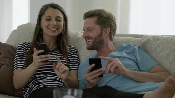 Hipster Couple With Smartphones on sofa