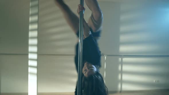 Young Sexy Woman Exercise Pole Dance Against a Gray Background alt